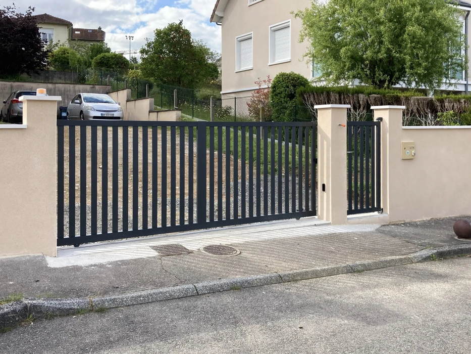 Scène extérieure résidentielle avec portail coulissant automatique et portillon piéton