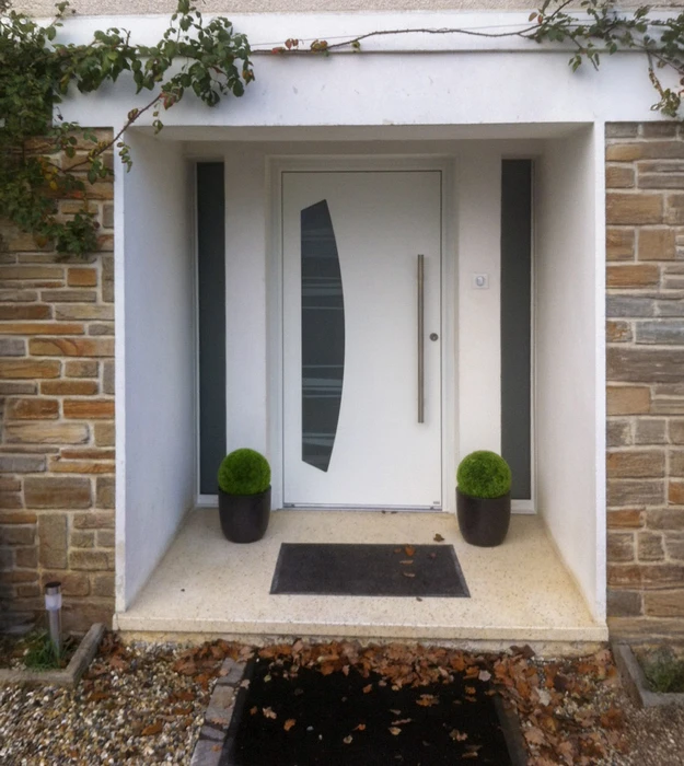 Entrée moderne d'une maison contemporaine avec porte d'entrée blanche à insert vitré vertical foncé et poignée longue métallique
