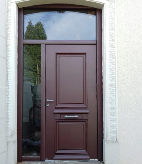 Entrée extérieure d'habitation avec porte d'entrée en bois marron foncé à panneaux moulurés