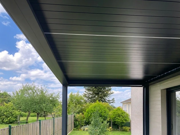Installateur professionnel en casquette effectuant la pose d'une fenêtre PVC blanche à double vitrage dans un intérieur résidentiel