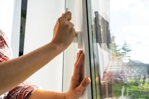maître met une nouvelle fenêtre double vitrage dans une fenêtre en plastique